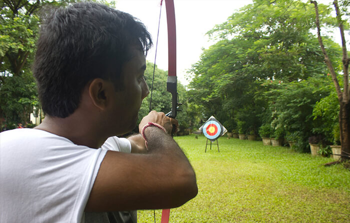 Man aiming bow at archery target